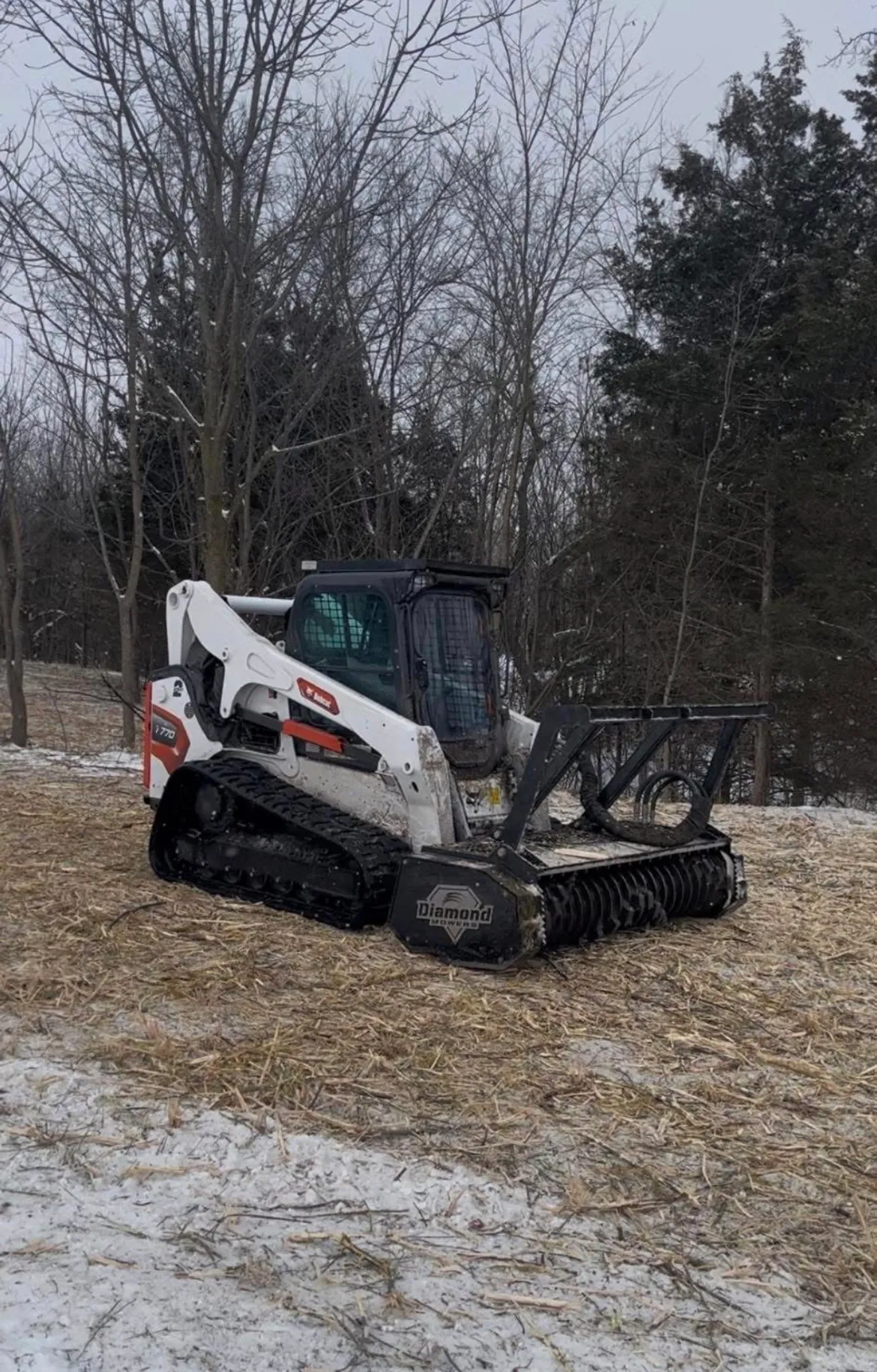 Track skid steer with mulcher head operating in winter conditions during debris removal, Lenawee County Michigan