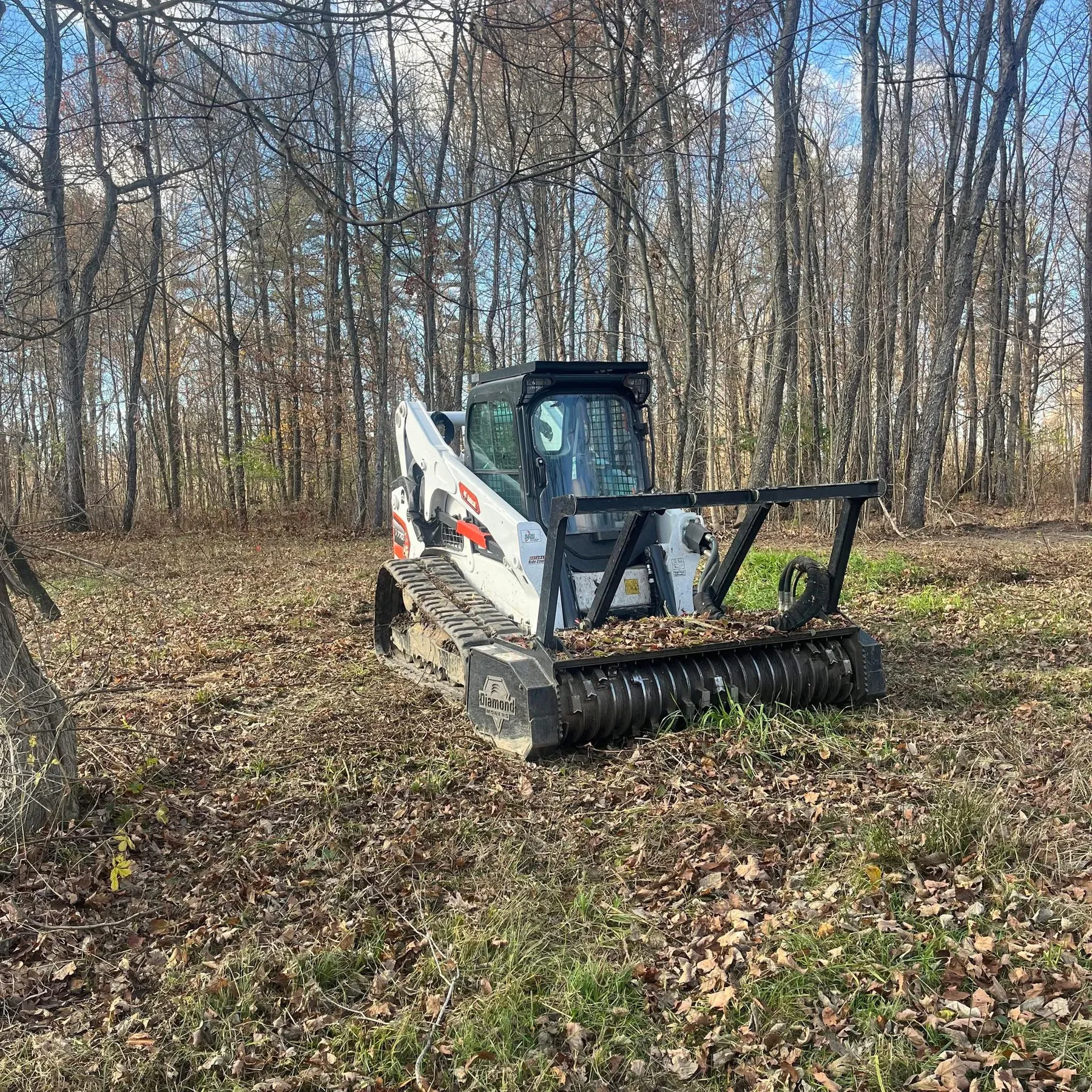 Bobcat track skid steer with forestry mulcher working in Northwest Ohio woodland, Defiance County